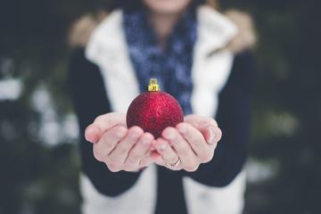 Female Hands Holding Christmas Ball Outdoors
