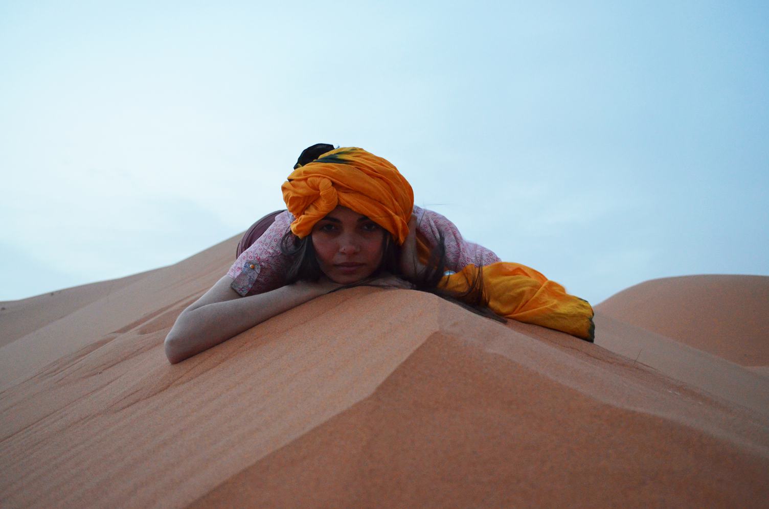 Woman in a Turban Is Lying on the Sand Dune