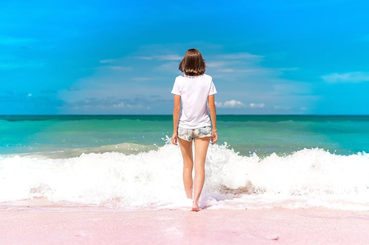 Girl Standing in Water on Seashore