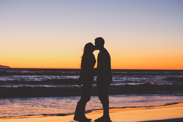 Couple Kissing on the Beach against Beautiful Sunset