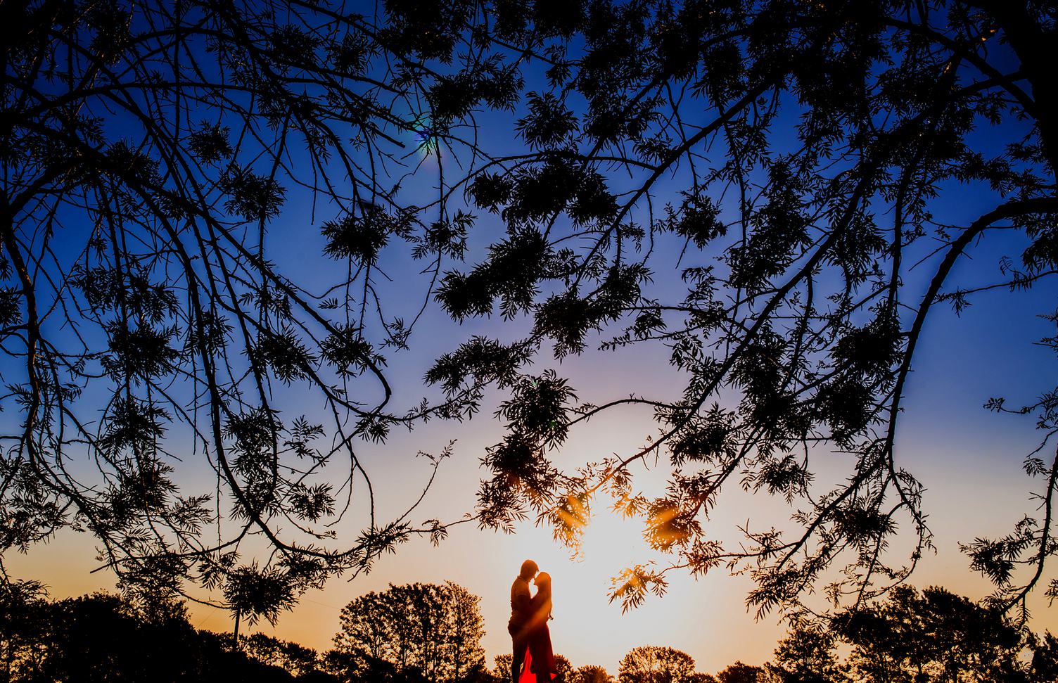 Young Couple Enjoying the Sunset in the Meadow